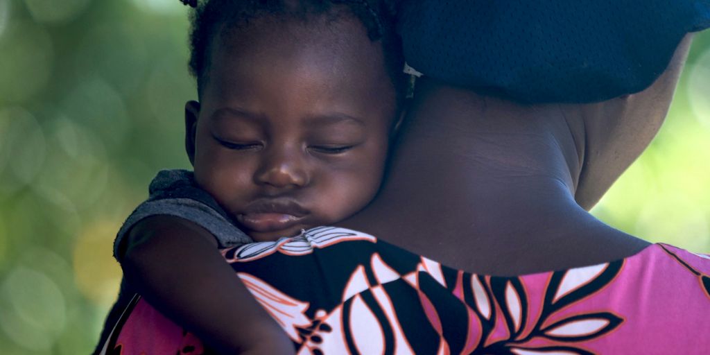 girls sleeping on mother's shoulder