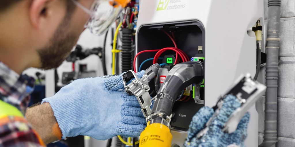 Electrician inspecting EV charger with tools and equipment.