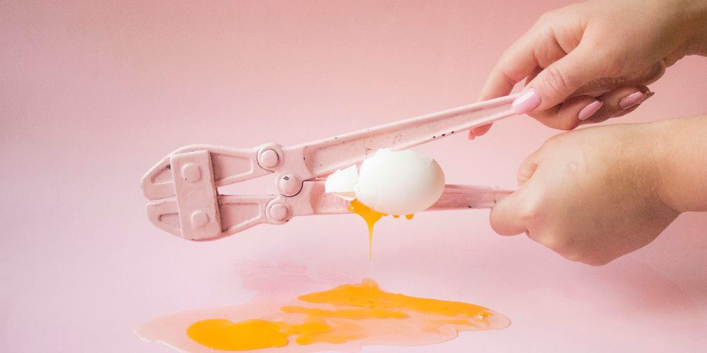 person holding white plastic spoon with yellow powder