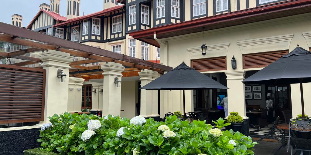 a courtyard with flowers and a building in the background