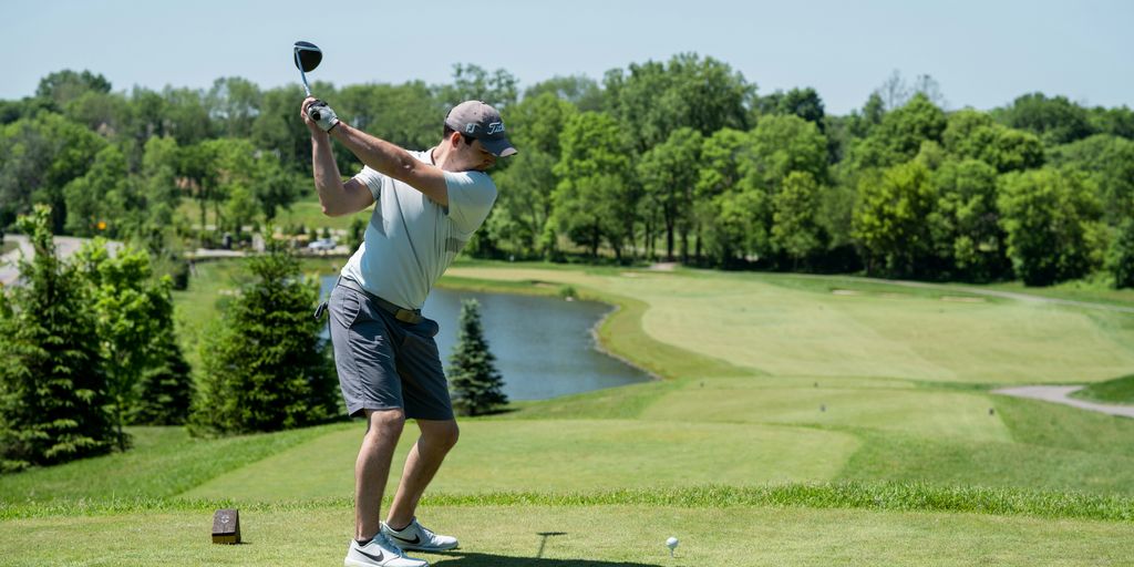man in white t-shirt and black shorts playing golf during daytime