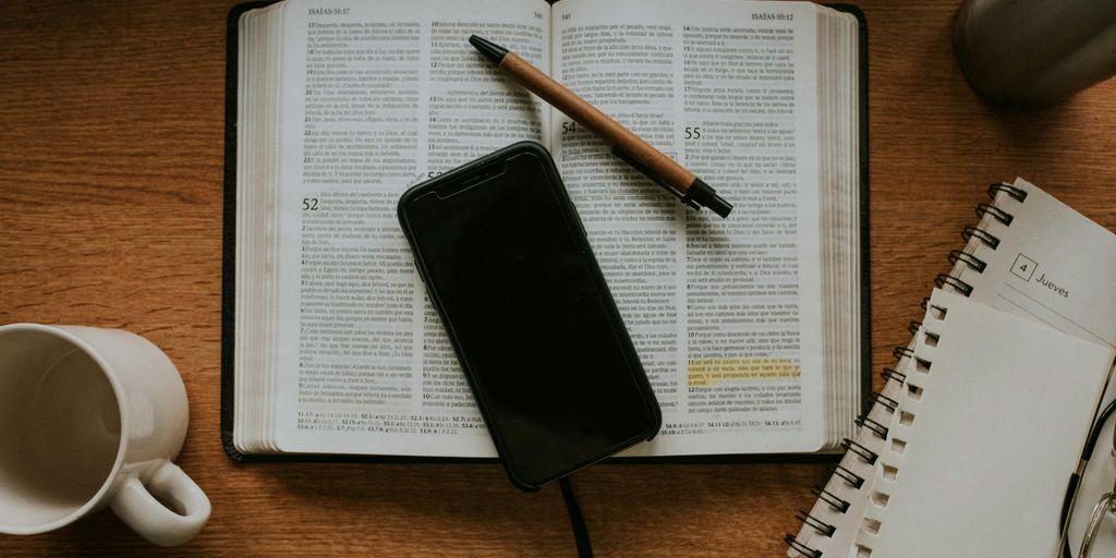 black smartphone on white notebook