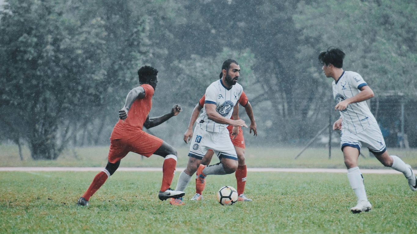 men playing soccer on green grass field during daytime