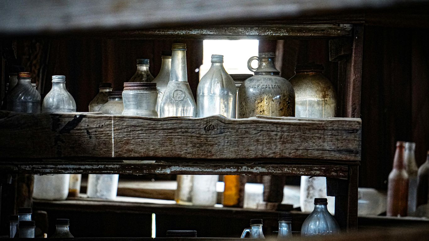 a wooden shelf filled with lots of glass bottles