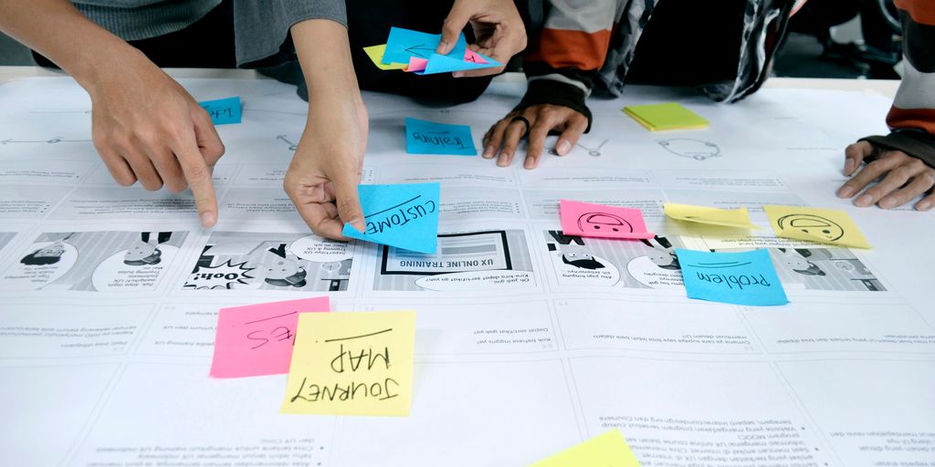 person in gray shirt holding white printer paper