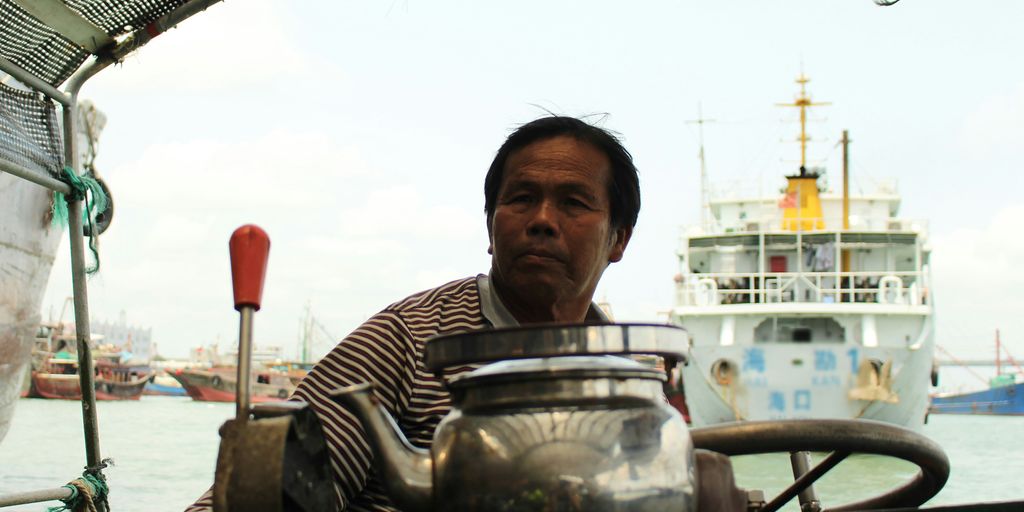 man in black and white striped polo shirt holding stainless steel jar