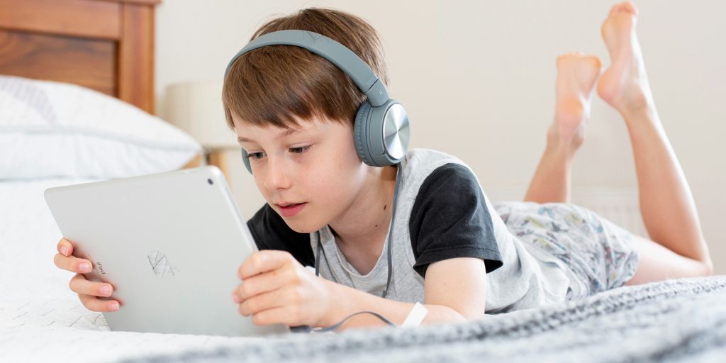 boy in black shirt using white laptop computer