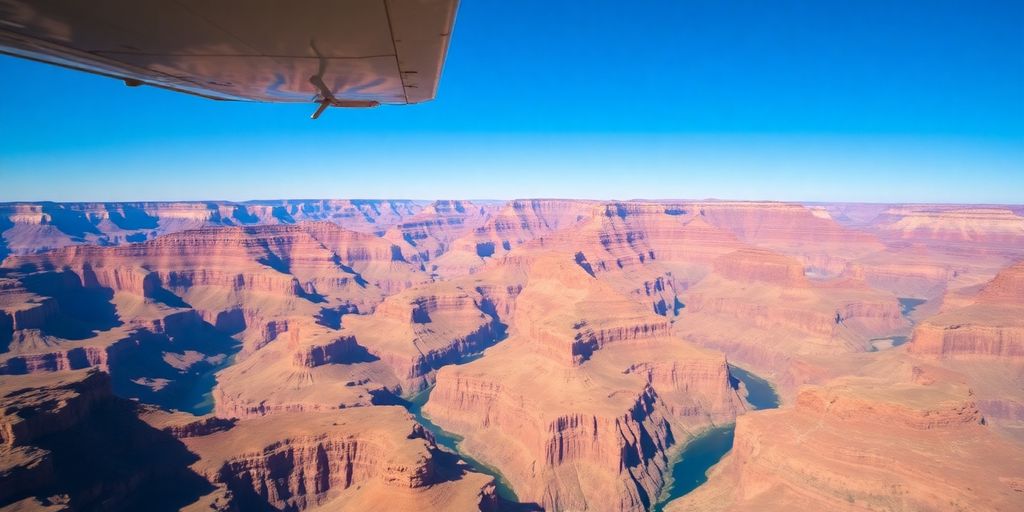 A small airplane flies over the vast Grand Canyon.