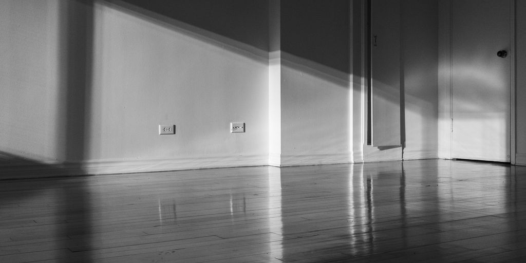 a black and white photo of a room with a door