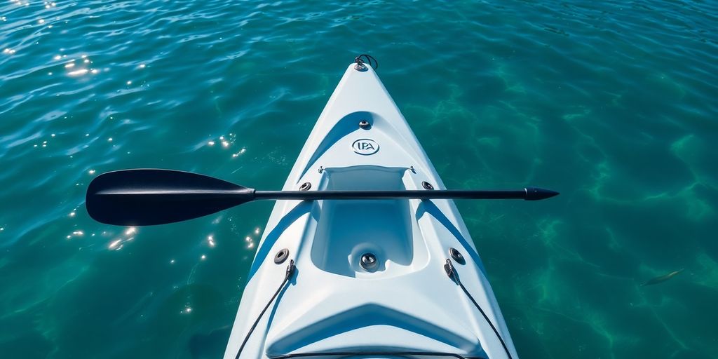 Fishing kayak on calm water with a paddle.