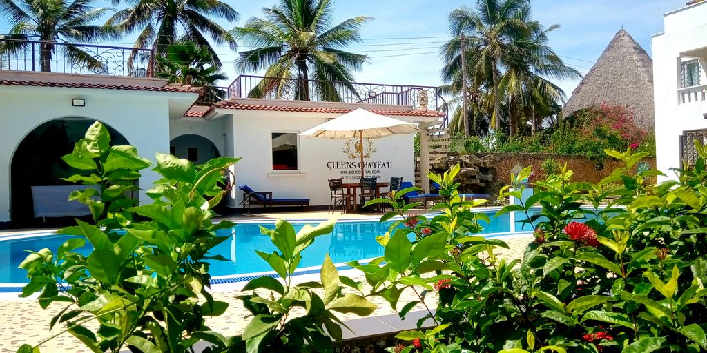 a hotel with a swimming pool surrounded by greenery