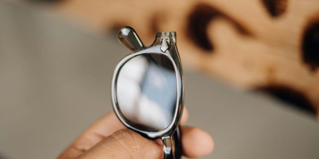 a person holding a pair of glasses in their hand