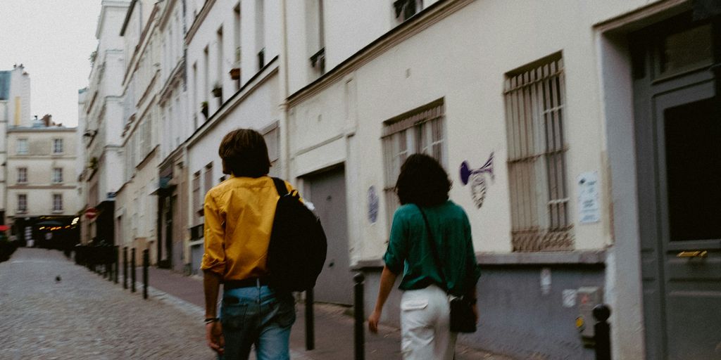 a couple of people walking down a street