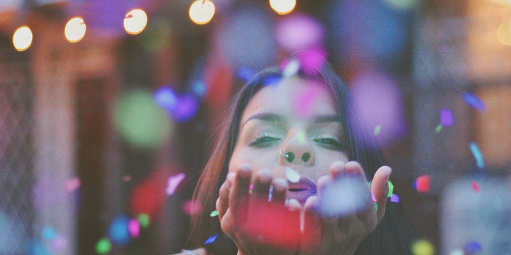 woman blowing confettis