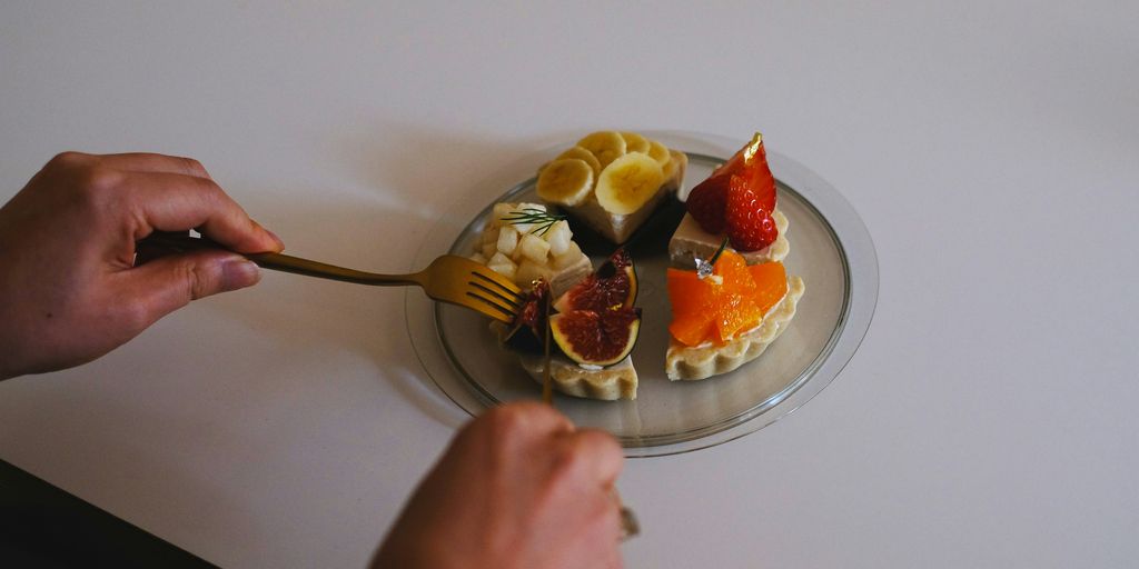 a person holding a spoon over a plate of food