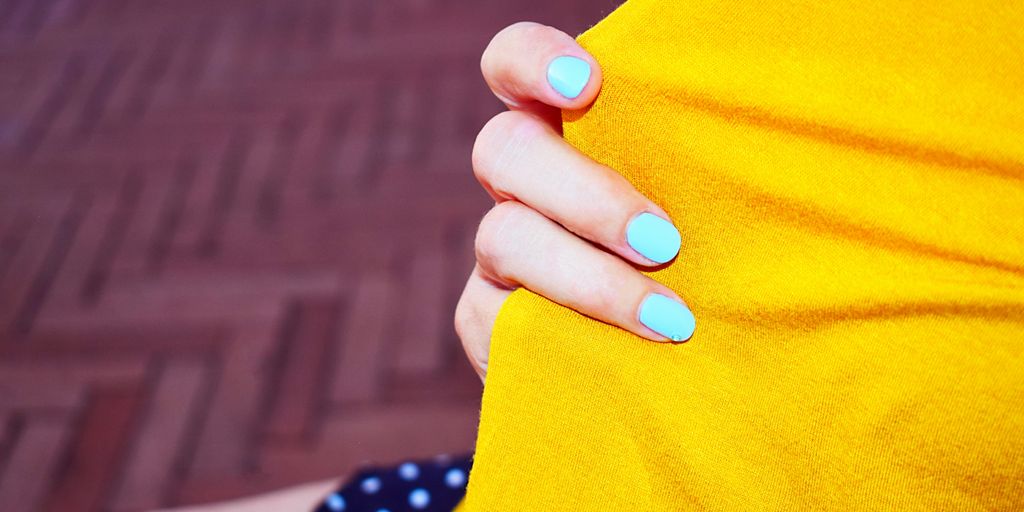 person with blue manicure holding orange textile