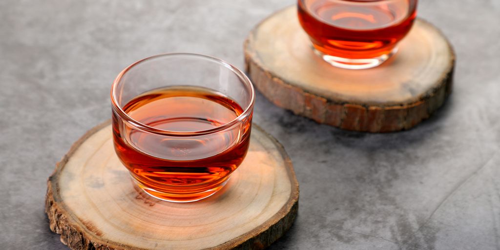 clear glass cup with red liquid on brown wooden table