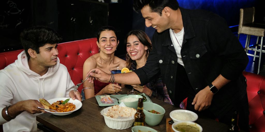 a group of people sitting around a table eating food