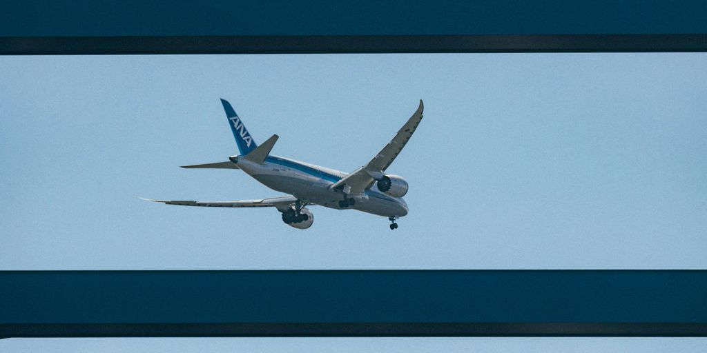 An airplane is flying through the blue sky