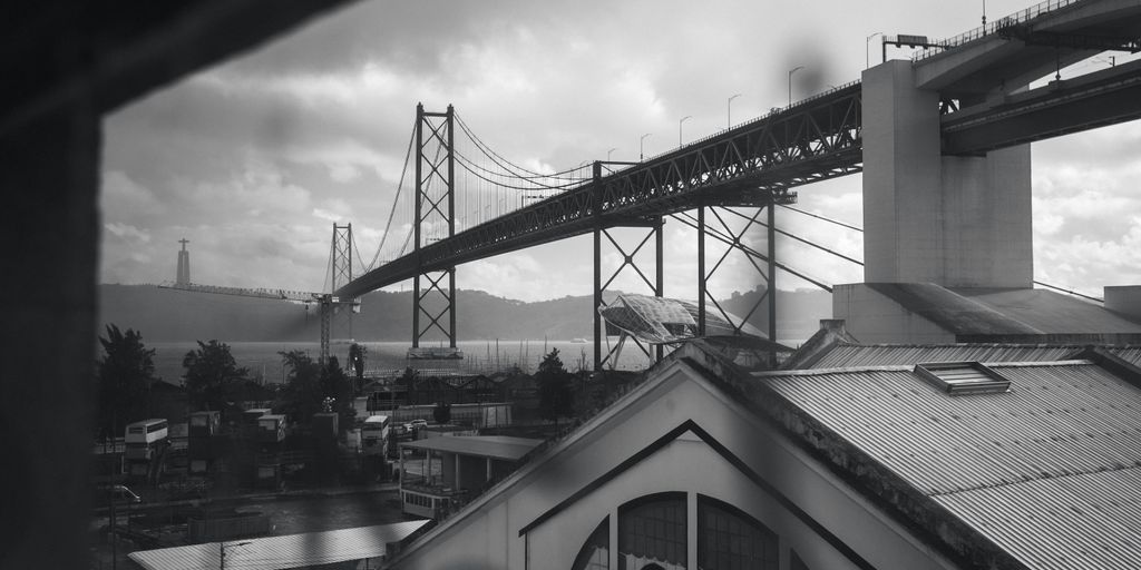 a black and white photo of a bridge over a city