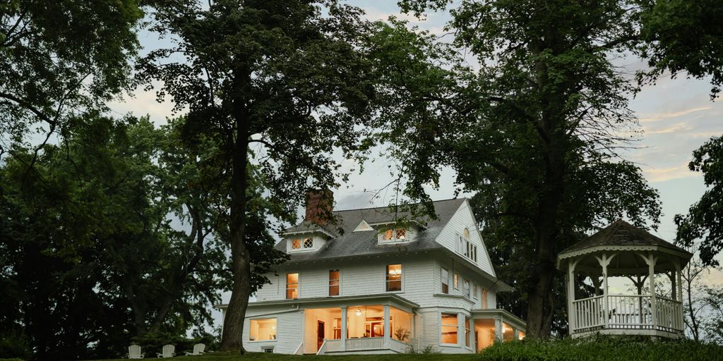 A large white house sitting on top of a lush green hillside