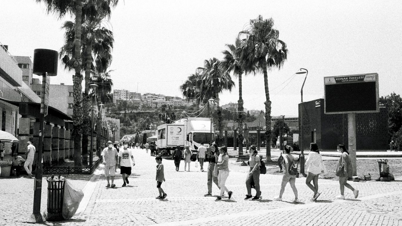 a black and white photo of people walking down a street
