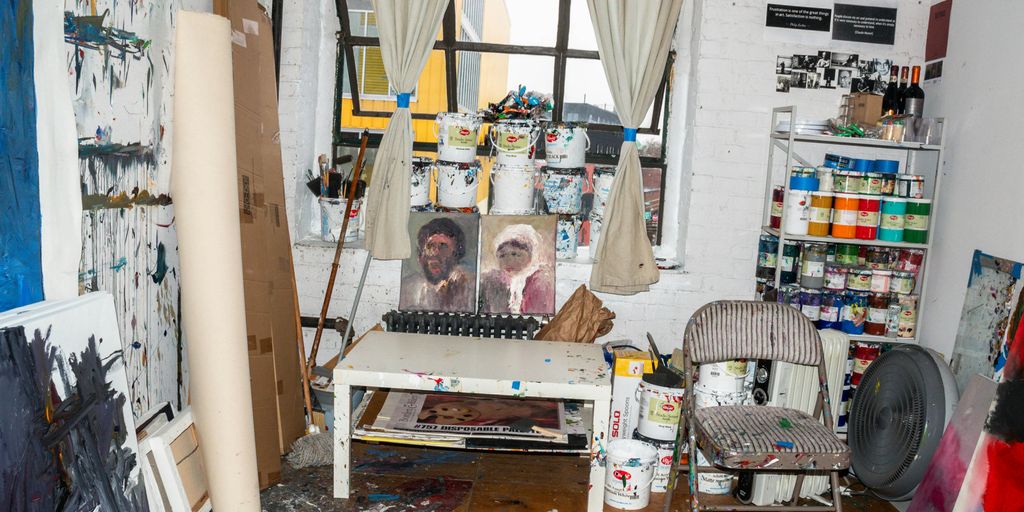 a messy room with a painting on the wall