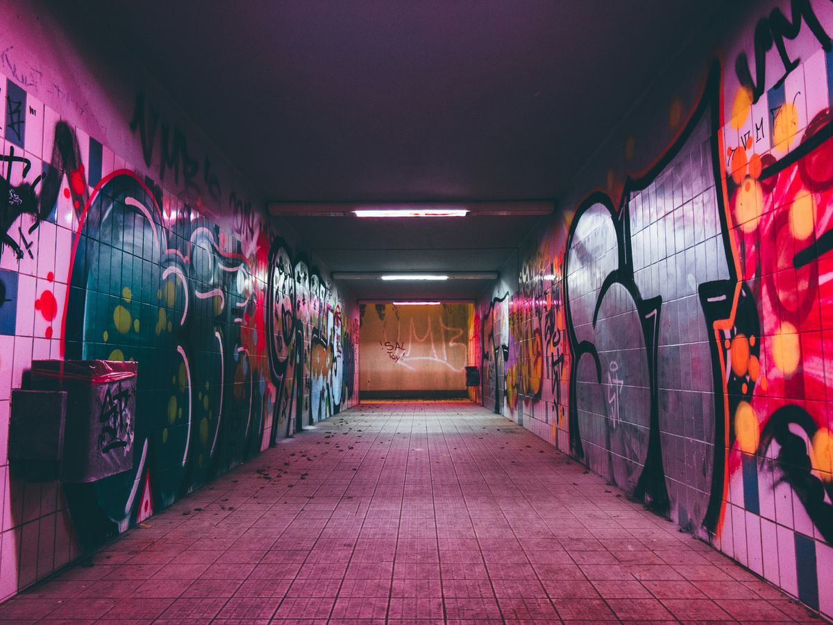 empty tunnel pathway with graffiti walls