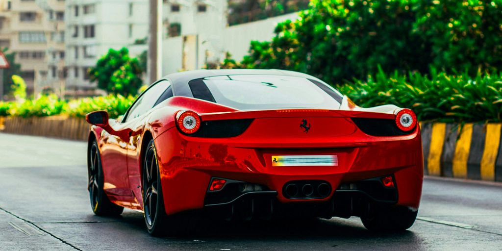 A red sports car driving down a street