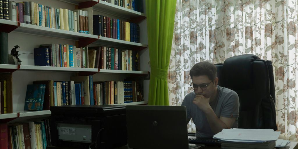 a man sitting at a desk in front of a laptop computer