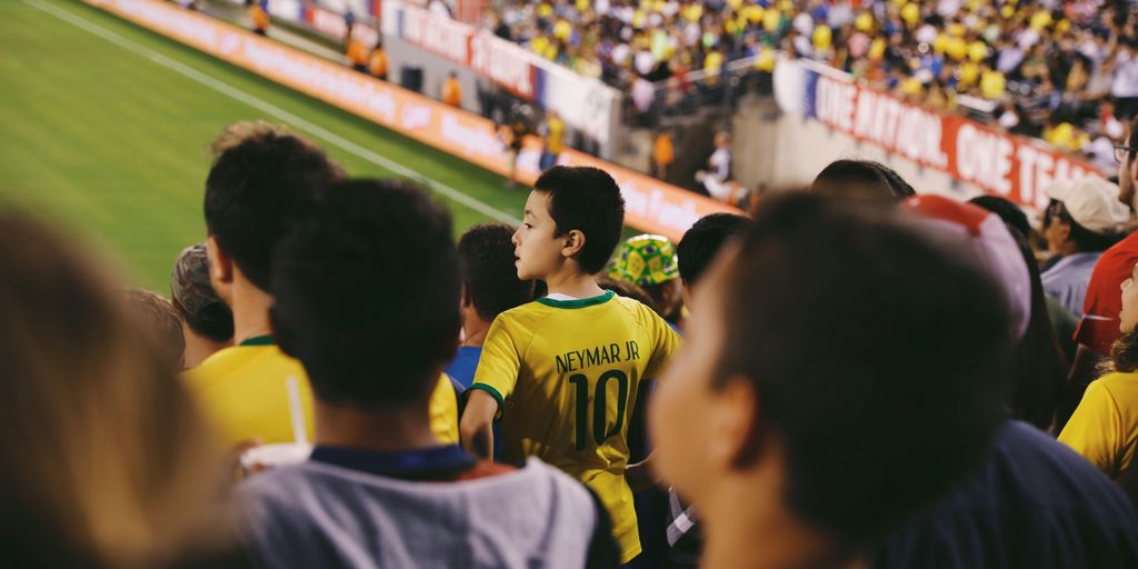 a group of people standing on top of a soccer field
