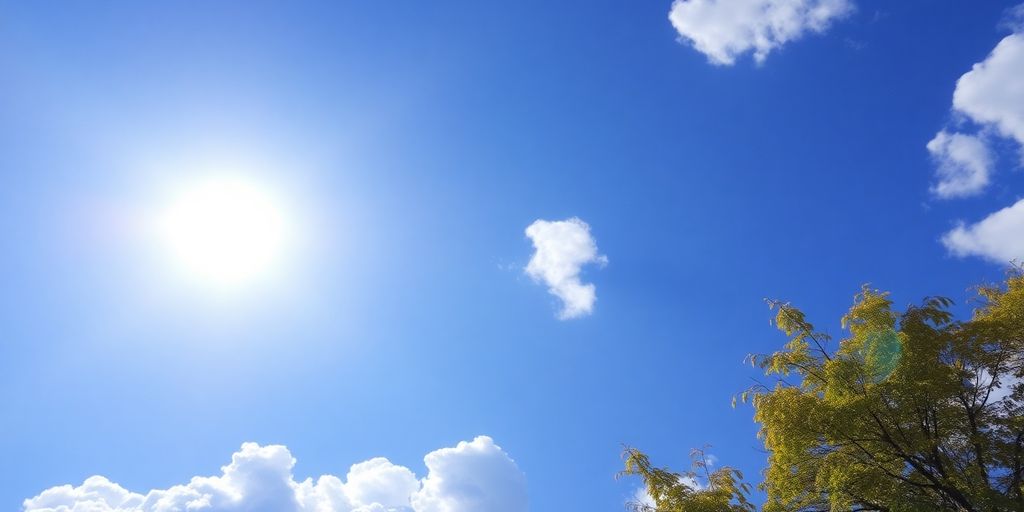 Ciel bleu avec soleil éclatant, quelques nuages blancs.