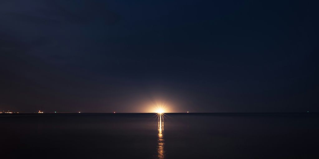 light post on the sea during night time