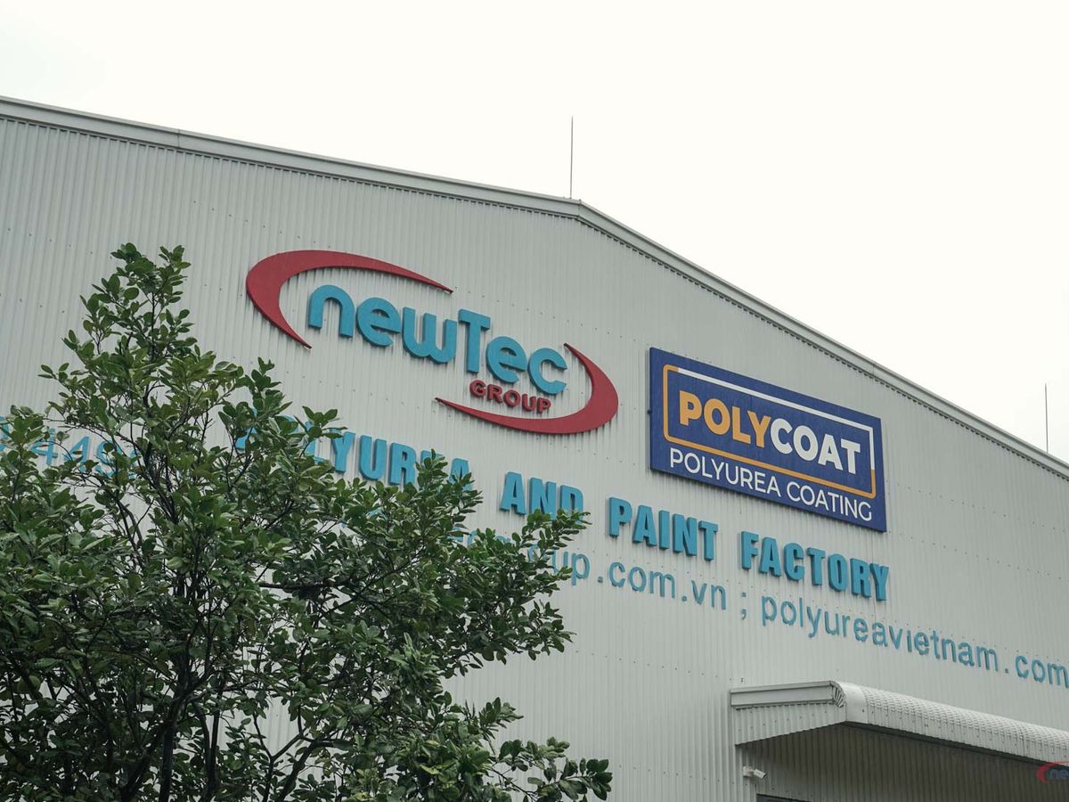 Building exterior featuring signs for NewTec Group and Polycoat.