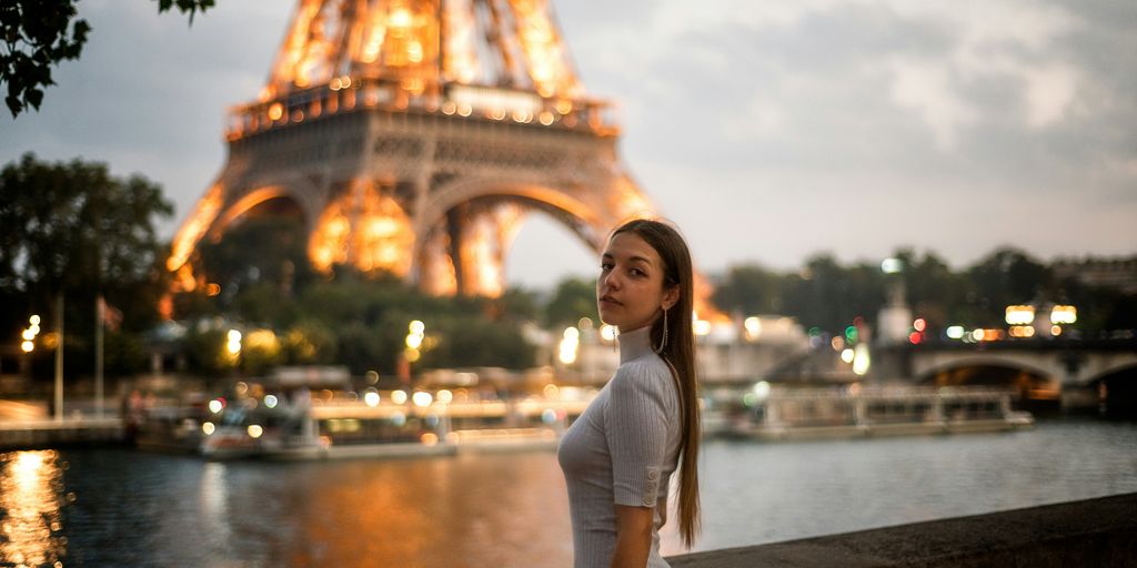 a woman standing in front of the eiffel tower