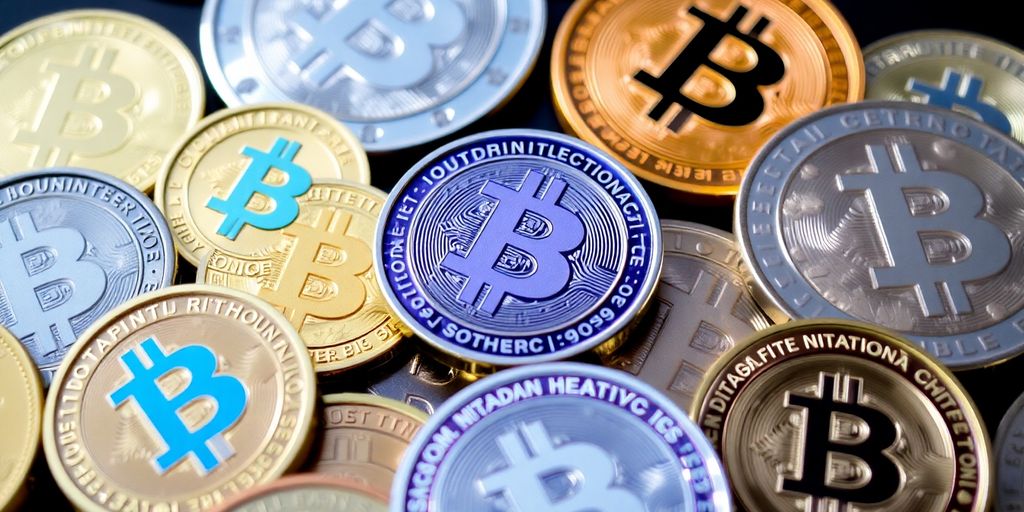 Diversas criptomoedas dispostas sobre uma mesa.