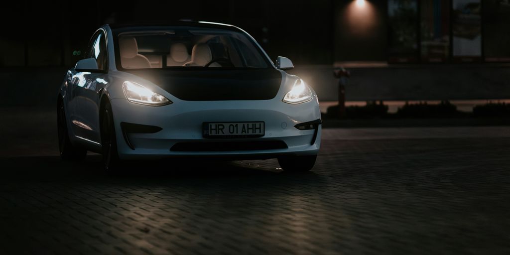 a white car parked in front of a building at night