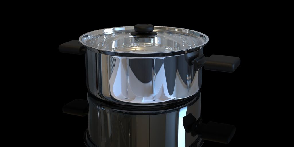 a stainless steel pot with a lid on a black background