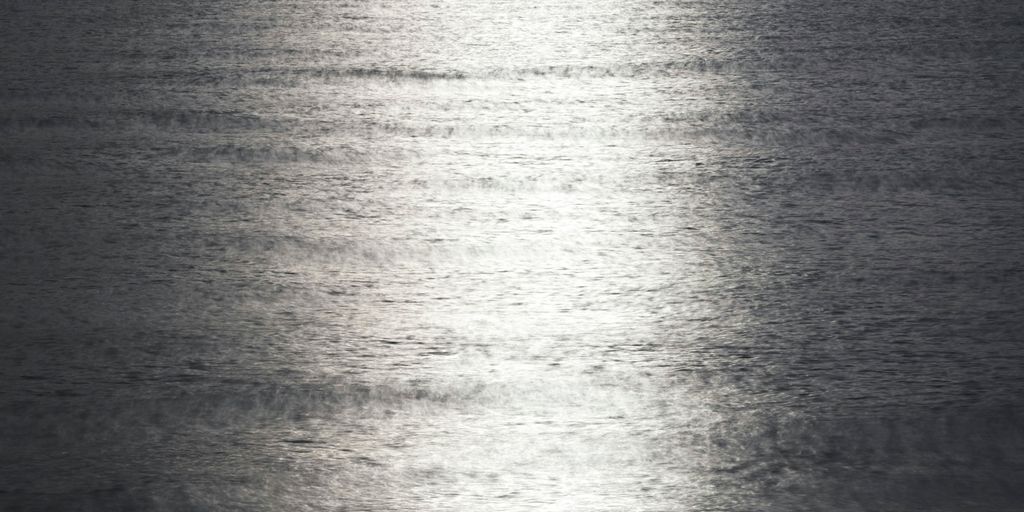 a large body of water with a boat in the distance