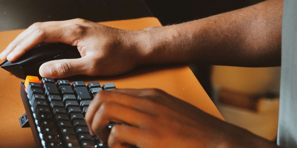 a person using a computer keyboard and mouse