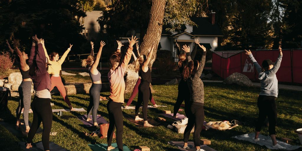 a group of people doing yoga in a park