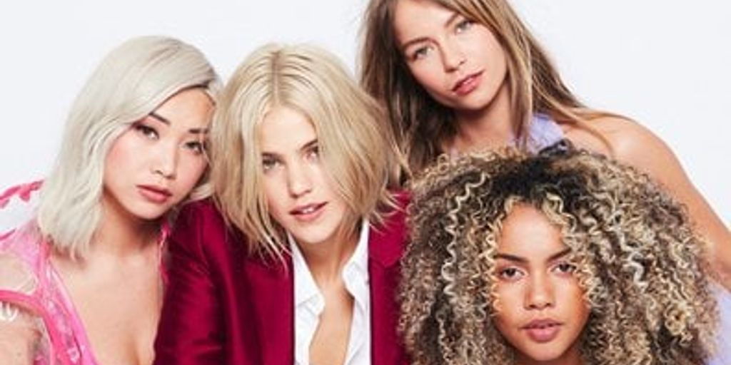 Four diverse women posing together, showcasing beauty and confidence.