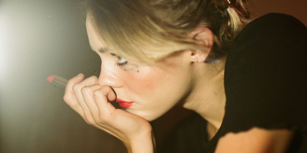 woman holding a red lipstick
