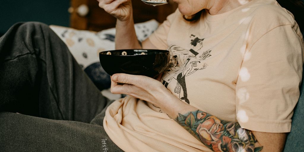 woman in white floral long sleeve shirt holding black ceramic mug