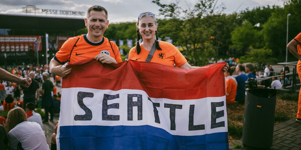 A couple of people holding a flag in front of a crowd