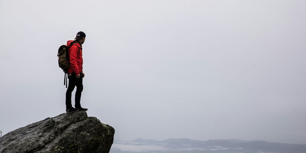 person standing on gray rock