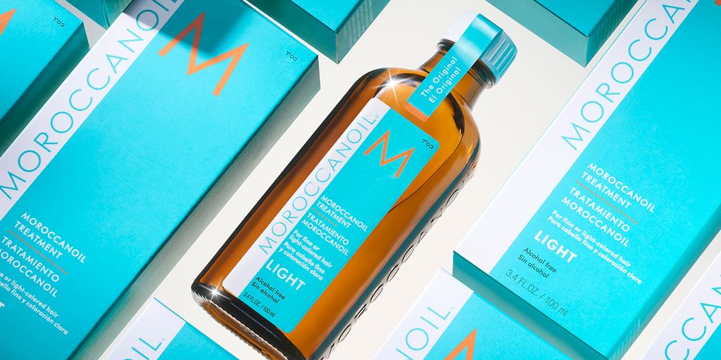 Moroccanoil hair treatment bottle surrounded by branded turquoise boxes.