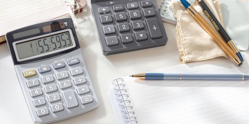 Organized workspace with calculator, notebook, and pens.