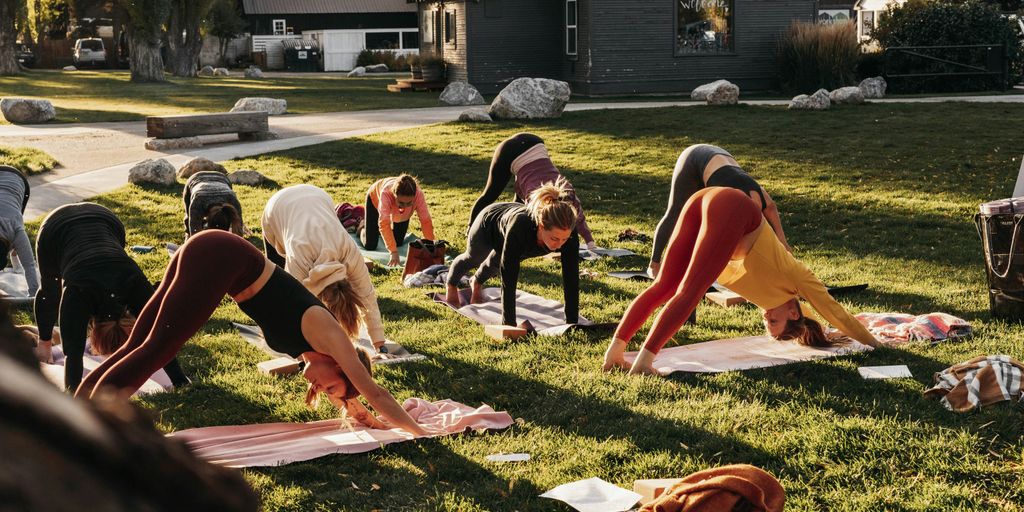 a group of people doing yoga in the grass