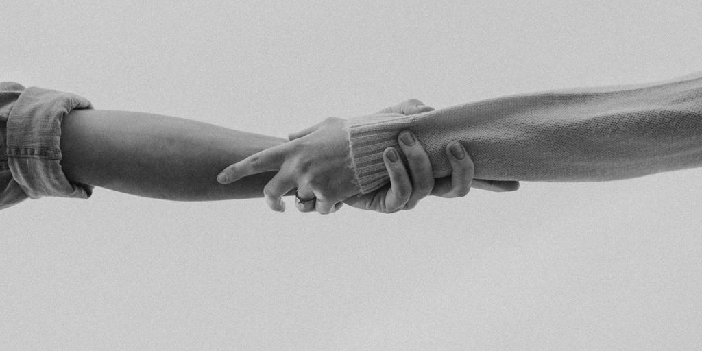 grayscale photo of person holding hands